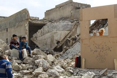 In this photo taken on March 27, 2019, children watch a puppet show performed by a Syrian actor, through a makeshift puppet theatre set up among the rubble of collapsed buildings in the town of Saraqib in northern Idlib province. AFP