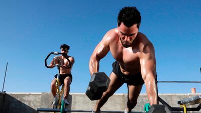 Palestinian bodybuilding trainer Muhammad Jaafreh practices during a training session on his building's roof with his student Abed Ghurayyib, as the gym is closed amid the lockdown in the village of Tarqumiah, north-west of the occupied West Bank city of Hebron. AFP