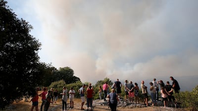 People look at smoke that fills the sky from a forest fire near Seillons in the Var department, France, on July 25, 2017. Reuters /Jean-Paul Pelissier