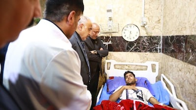 A handout image released by the press office of Iraqi Prime Minister Adel Abdel Mahdi on September 10, 2019 shows him visiting an injured person at the hospital in Baghdad, Iraq, on September 10, 2019. AFP