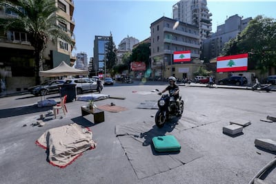 Anti-government protesters remove tents from the main motorway leading to east Beirut. EPA
