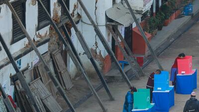Nepalese people cast their votes in front of a damaged building supported by wooden pillars during the second round of elections. Narendra Shrestha / EPA