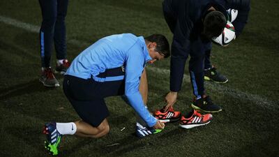Fernando Torres puts on his boots during his training session with Atletico Madrid on Tuesday. Susana Vera / Reuters