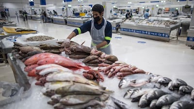 A seller wearing a protective mask at the fish market in Dubai. The Dubai authorities reopened some fish, meat and vegetables markets to the public after they were closed weeks ago to limit spread of the covid-19 coronavirus. EPA