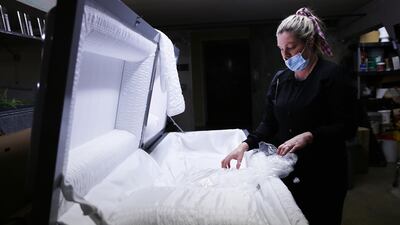 Embalmer and funeral director Kristy Oliver unwraps a new casket which will be used for a person who died from Covid-19 in El Cajon, California, January 15, 2020. Getty Images/AFP