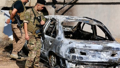 Lebanese army soldiers stand next to a vehicle that was supposedly targeted by an Israeli drone near the mosque of Zarout, between the towns of Jiyeh and Barja, south of Beirut, Lebanon this week. EPA