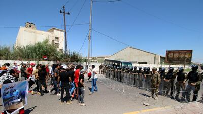 Iraqi security forces block the road in front of the demonstrators during an anti-government protest in front of the Governorate building in Basra, Iraq. Reuters