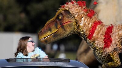 Hudson Mahaffay reacts to a staff member dressed like a raptor at the Jurassic Quest drive-thru Experience outside The Rose Bowl Stadium in Pasadena, California. Reuters