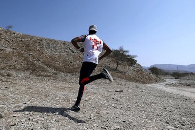 Frank Golya from Kenya running in the mountains near his home in Ras Al Khaimah. Pawan Singh / The National