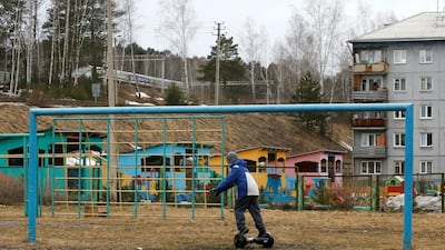 A boy rides a scooter near a goalpost on a football pitch in the Siberian town of Divnogorsk, Russia. Ilya Naymushin / Reuters