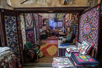 An Egyptian craftsman sits working on a tapestry in his shop in Khayamiya Street. The handicraft has seen a decrease in artisans in recent years. AFP / Mohamed el-Shahed