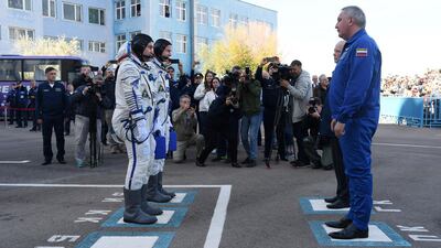Nick Hague and Alexey Ovchinin report to Roscosmos head Dmitry Rogozin before boarding the Soyuz spacecraft. AFP