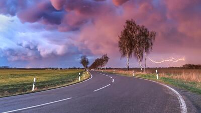 'Mammatus Outbreak', Boris Jordan: 'This was by far the most spectacular mammatus display I've ever seen in my entire life. After a line of thunderstorms passed by and the sun disappeared behind the horizon, low-hanging mammatus clouds began to shine red and blue. At this moment I was just speechless, as the sky really looked like not from this planet. And as a nice bonus, distant lightning made the composition perfect. Mammatus mostly appear in association with strong thunderstorms, if the sinking air, which contains high amount of liquid water or ice, is cooler than the surrounding air.'