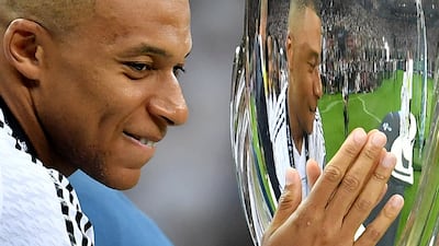 Real Madrid's Kylian Mbappe touches the trophy ahead of the presentation ceremony. Reuters