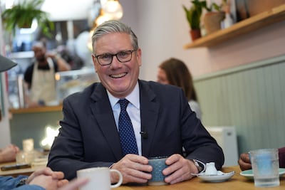 Keir Starmer speaks to small business owners during a visit to a cafe in London. Reuters