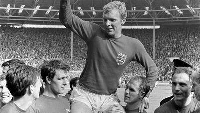 England captain Bobby Moore holds the 1966 World Cup trophy, cheered by Martin Peters, Geoff Hurst, Moore, Ray Wilson, George Cohen, and Bobby Charlton. PA