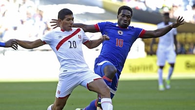 Peru forward Edison Flores, left, battles for the ball with Haiti midfielder Jeff Louis at CenturyLink Field in Seattle. Ted S. Warren / AP Photo