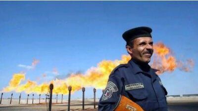 An officer guards a section of the Barjisiya oil fields near Basra. The field's gas is currently flared off. AFP PHOTO / ESSAM AL-SUDANI