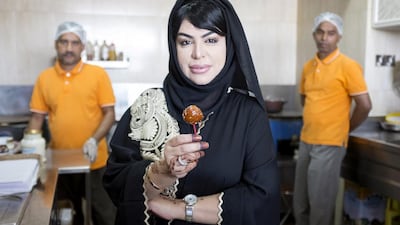 Zahra Ali at her restaurant Dar Al Bajila Wa Nakhi (House of Broad Beans and Chickpeas). She holds a luqaimat, which she prepares daily in the kitchen of her home. Photos Reem Mohammed / The National