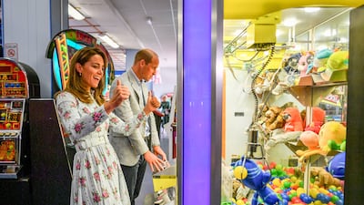 The royal couple play a grab-a-teddy game during a visit to Barry Island, South Wales, to speak to local business owners about the effect of Covid-19 on the tourism sector in August 2020