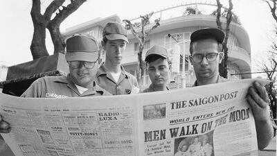US soldiers read a newspaper headlining the Apollo 11 moon landing, in downtown Saigon, Vietnam. AP Photo