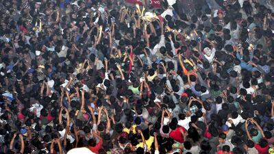 In this March 5, 2015 photo, members of a mob raise their hands to take photos of a man, top centre, accused of rape, after he was lynched and strung up from the clock tower in Dimapur city, in the northeastern Indian state of Nagaland. Imojen I Jamir/AP Photo