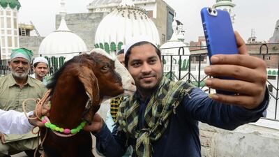 A man takes a selfie with a goat after Eid al-Adha prayers at the Khairuddin Mosque in Amritsar. AFP