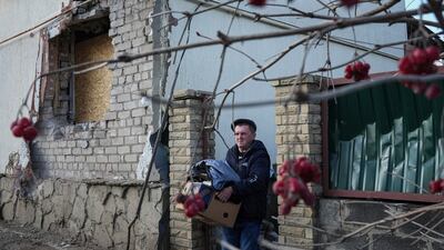A man removes his belongings from his house after it was struck by artillery shells in Novoluhanske, eastern Ukraine. AP