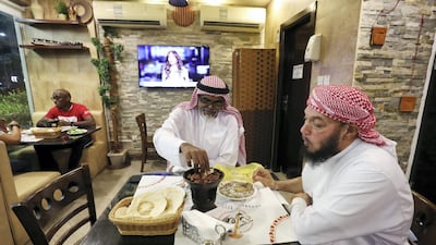 Two men have dinner at Al Mufraka restaurant, Abu Dhabi in 2019. More restaurants outside malls in the capital are reopening. Chris Whiteoak / The National