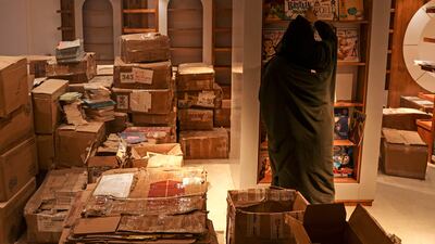 A worker arranges bookshelves ahead of the opening of the new Samir Mansour bookshop that was destroyed during last year's 11-day war between Israel and the Palestinian Hamas movement, in Gaza City.