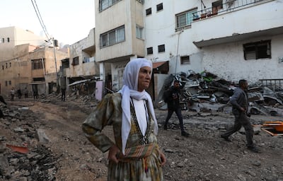 Palestinians stand at a damaged area inside the Jenin refugee camp following an Israeli raid, in the West Bank city of Jenin, November 9, 2023. EPA