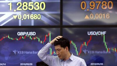A currency trader walks by the screens showing the foreign exchange rates at the foreign exchange dealing room in Seoul, South Korea, on Wednesday July 6, 2016. Lee Jin-man / AP Photo