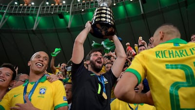 Brazil's goalkeeper Alisson raises the trophy. AFP