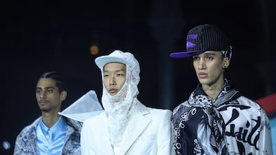 Three models present the final collection, featuring lace, graffiti and silk, by designer Virgil Abloh for Louis Vuitton. EPA