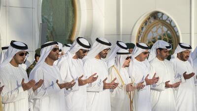 Sheikh Mohammed bin Zayed, centre, Crown Prince of Abu Dhabi and Deputy Supreme Commander of the Armed Forces, prays at the tomb of his late father Sheikh Zayed after Eid Al Adha prayers yesterday at the Sheikh Zayed Grand Mosque in Abu Dhabi. Ryan Carter / Crown Prince Court – Abu Dhabi