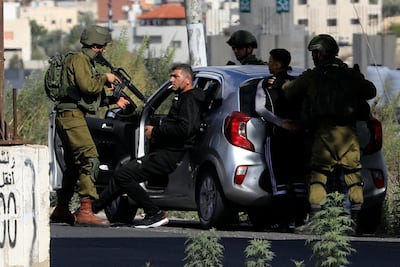 Israeli soldiers detain a Palestinian at a checkpoint in Hawara. AFP