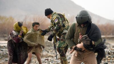An Afghan air force crew member carries a child during an evacuation operation in a flood affected area of Arghandab district in Kandahar province. AFP