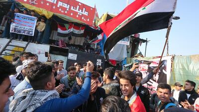 Iraqi anti-government protesters wave a natioanl flag as they chant during ongoing demonstrations in the capital Baghdad's Tahrir square. AFP