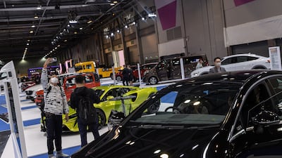 A visitor takes a selfie among cars on display during the International Motor Expo in Hong Kong in December 2021. EPA