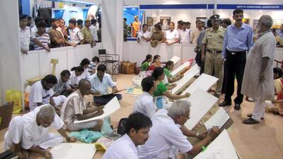 The artist Chitta Dey, standing in the beige kurta, talks to Kolkata’s commissioner of police Surajit Purakaystha, in blue, while overlooking a heavily guarded art class of convicts from the city’s Alipore jail. Courtesy West Bengal Correctional Services