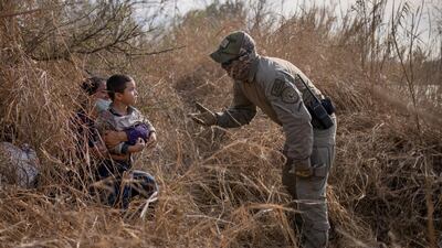 A Texas State Trooper asks asylum-seeking migrants to come out of hiding after the Honduran nationals crossed the Rio Grande into the US from Mexico, March 9, 2021. Reuters