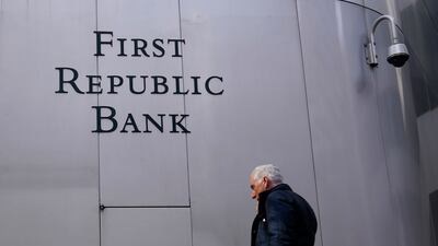 A pedestrian walks past a sign at a First Republic Bank in San Francisco. The troubled lender will be sold to JP Morgan. AP