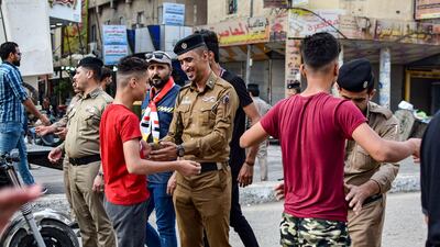 Iraqi policemen search youths on their way to attend an anti-government sit-in in Nasiriyah, the capital of the southern province of Dhi Qar. AFP