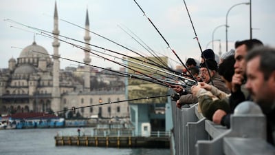 Anglers cast their lines into the waters of the Golden Horn from Istanbul's Galata Bridge. Oliver Berg/DPA via AP