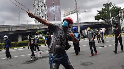 A protester uses a slingshot during a demonstration in Bangkok, calling for the resignation of Thailand's Prime Minister Prayut Chan-O-Cha over the government's handling of the Covid-19 crisis.