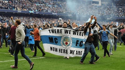 Manchester City fans invade the pitch after the final whistle, as Manchester City are crowned Premier League champions on Sunday. Rui Vieira / AP