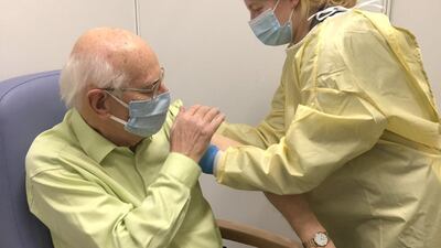 Charlotte Taylor administers the Covid-19 vaccine to her grandfather David Taylor at the ExCeL Centre in east London. Barts Health NHS