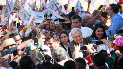 Mexican President Andres Manuel Lopez Obrador shakes hands with the crowd during a unity rally in Tijuana, Mexico. Getty Images