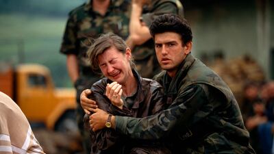 A Croatian man tries to comfort a woman as they and fellow Croats flee their village in Bosnia, in June 1993. Getty Images