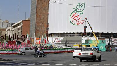 Road users pass a billboard in Valiasr Square, Tehran that reads in Farsi, 'the women of my land, Iran'. It had shown pictures of Iranian women, but some asked for their images to be removed. AFP